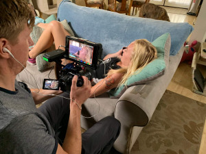 Let ’Em Play – Behind the Scenes Interview A camera operator films a young athlete reclining on a couch during an interview.